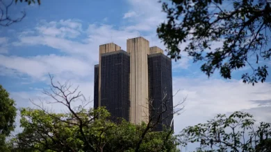 A discussão sobre política monetária do país tem como pano de fundo a fotografia da sede do Banco Central em Brasília. A decisão do BC manter taxas de juro elevadas por um longo período é confirmada pela ata do CMN, refletindo a preocupação com a inflação e estabilidade financeira, embora possa ter consequências negativas para a economia em curto prazo.