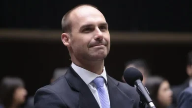 Eduardo Bolsonaro ameaça novas sanções contra autoridades brasileiras para afastar Alexandre de Moraes do STF. Deputado busca apoio de Donald Trump para impedir julgamento do ex-presidente Jair Bolsonaro. Moraes afirma ignorar as sanções e continuar com os processos.