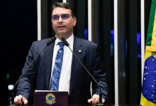 Senador Flávio Bolsonaro critica perseguição política a direita no Brasil em evento na Itália, defende Zambelli e Tagliaferro contra extradição.