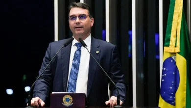 Senador Flávio Bolsonaro critica perseguição política a direita no Brasil em evento na Itália, defende Zambelli e Tagliaferro contra extradição.