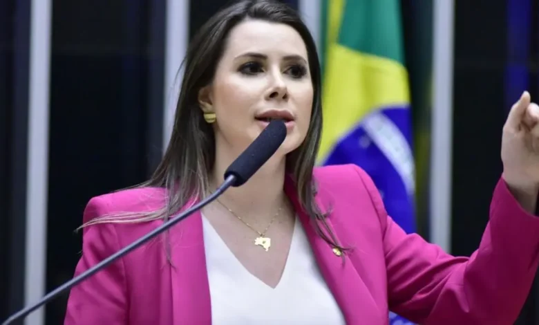 Deputada Caroline De Toni renuncia ao cargo de líder da minoria na Câmara para proteger o mandato de Eduardo Bolsonaro, que reside nos EUA. A decisão visa evitar a cassação do mandato de Eduardo, alvo de pressão por deputados do governo.