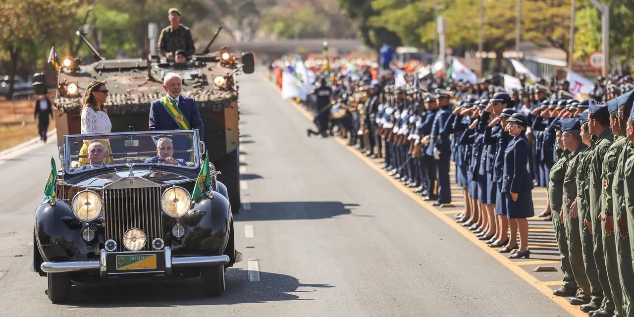 Desfile cívico de 7 de setembro na Esplanada dos Ministérios: grandiosidade militar, marchas sincronizadas, orquestras, veículos de guerra e esquadrilha da fumaça. Presidente Lula presente.