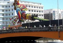 A escultura do Galo Folião Fraterno, localizada na Ponte Duarte Coelho, é um tributo ao legado de Dom Helder Câmara e Nise da Silveira, com materiais reciclados e arte 3D.